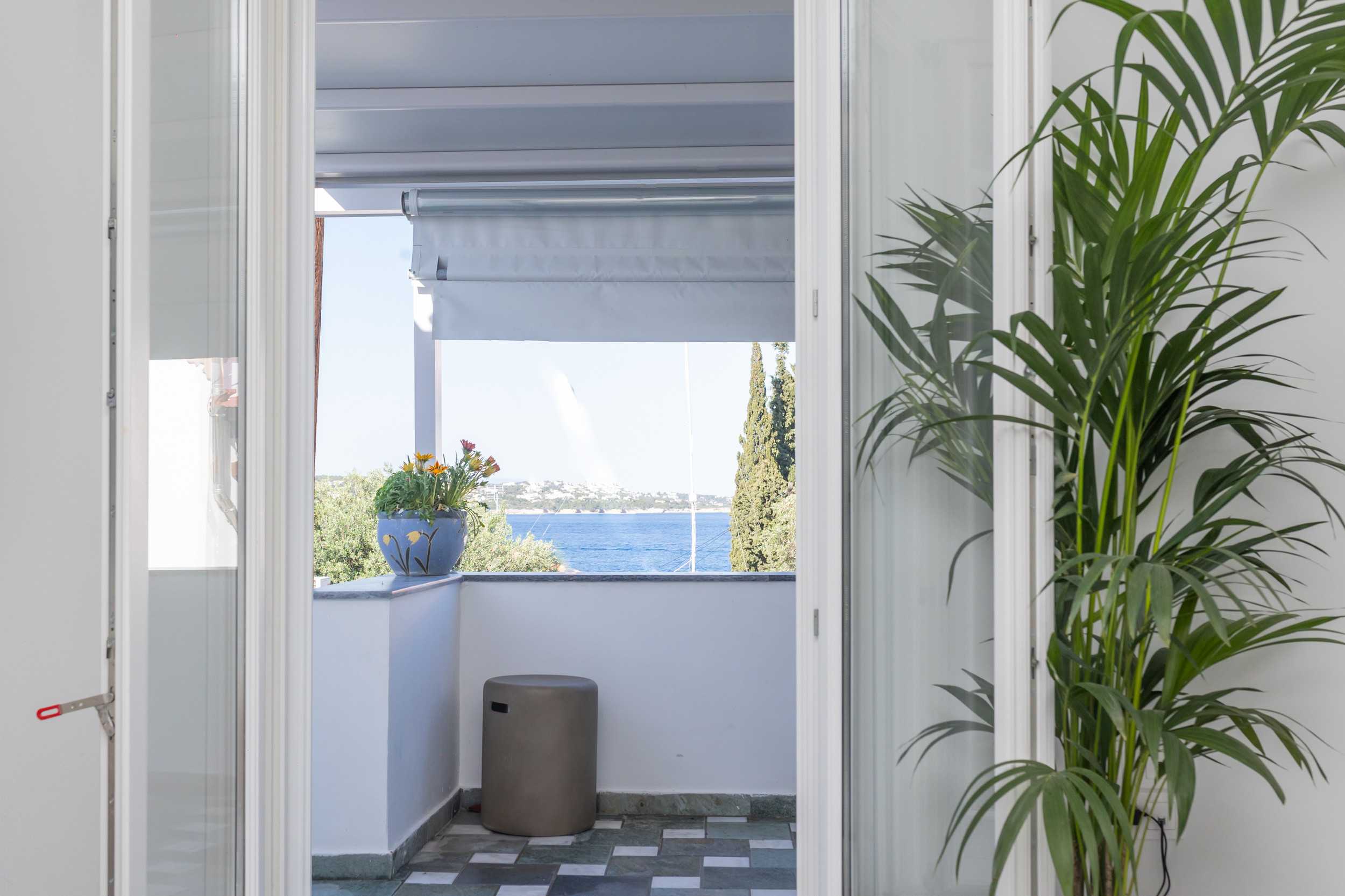 Mimoza's House — exterior framed by garden greenery